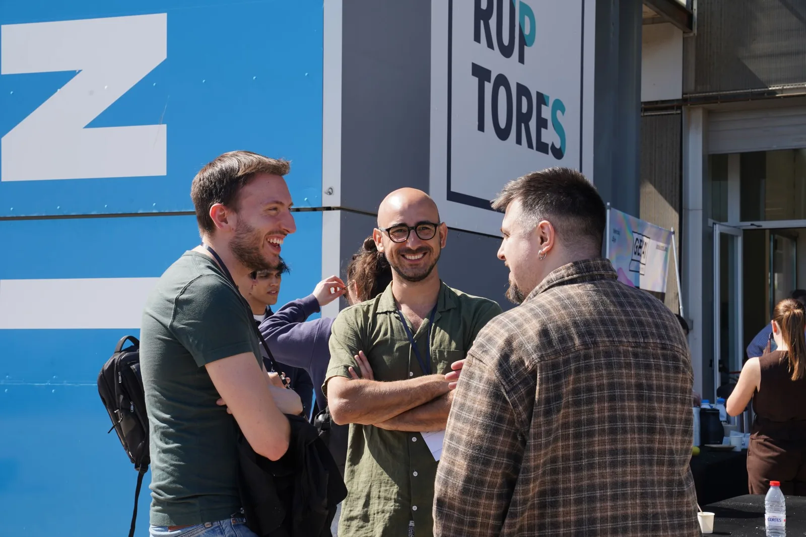 Three Gen AI Summit EU 2026 attendees talking outside the venue