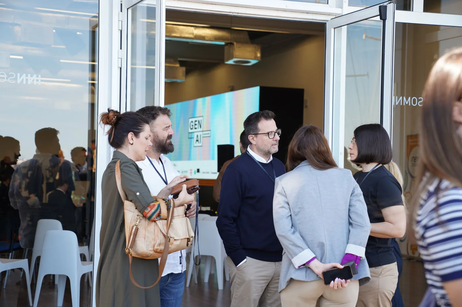 Attendees networking at the Gen AI Summit EU 2026 venue entrance, with the event screen in the background